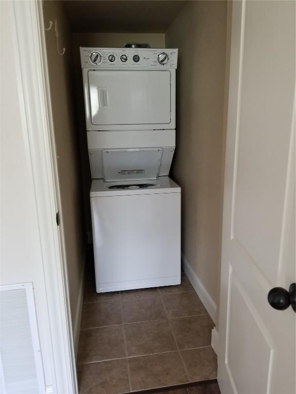 100 Granview Ct Unit 126, Iowa City, IA 52246 - laundry area with stacked washer / drying machine, baseboards, and dark tile patterned flooring