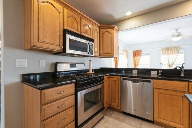 3010 Newcastle Rd, Marion, IA 52302 - kitchen featuring stainless steel appliances, a sink, dark stone counters, brown cabinets, and recessed lighting