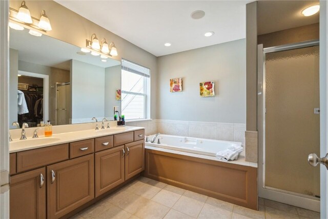 3010 Newcastle Rd, Marion, IA 52302 - full bathroom featuring a stall shower, a bath, double vanity, a walk in closet, and tile patterned flooring