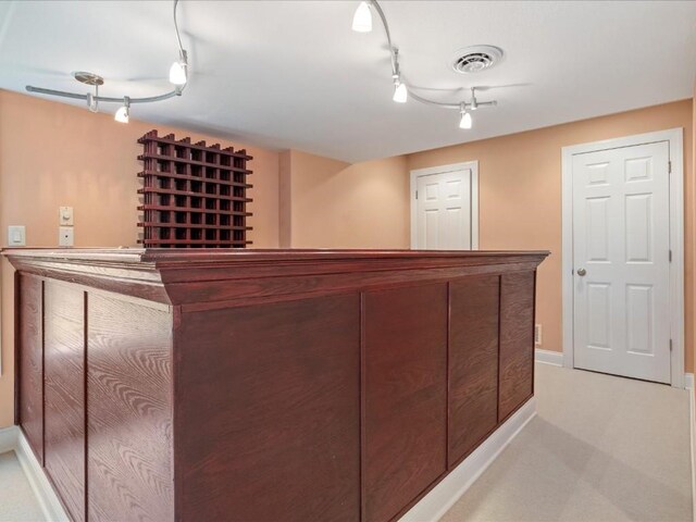 3010 Newcastle Rd, Marion, IA 52302 - indoor dry bar featuring rail lighting, light carpet, and baseboards