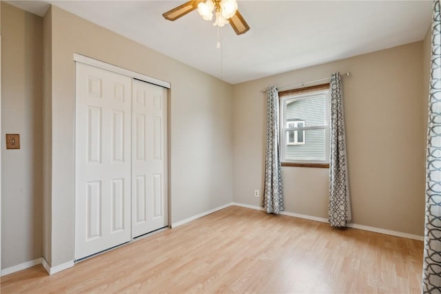 1056 Eisenhower Rd, Hiawatha, IA 52233 - unfurnished bedroom featuring light wood-style flooring, a closet, baseboards, and a ceiling fan