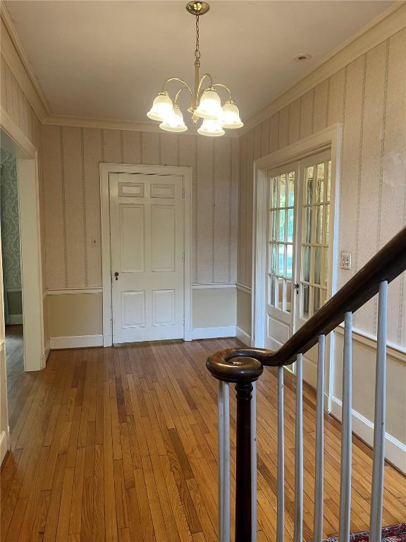 620 S Summit St, Iowa City, IA 52240 - foyer with ornamental molding, a chandelier, wood-type flooring, and baseboards