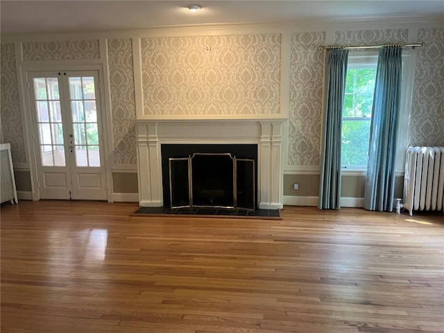 620 S Summit St, Iowa City, IA 52240 - unfurnished living room with radiator, wallpapered walls, wood-type flooring, a fireplace, and healthy amount of natural light