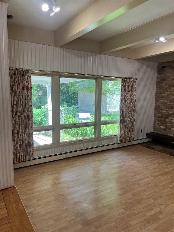 620 S Summit St, Iowa City, IA 52240 - spare room with wood finished floors, healthy amount of natural light, beam ceiling, and a baseboard heating unit