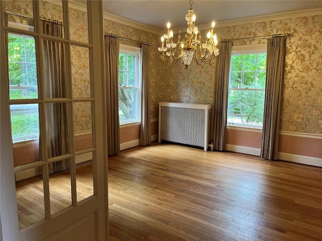620 S Summit St, Iowa City, IA 52240 - unfurnished dining area with a chandelier, hardwood / wood-style flooring, baseboards, ornamental molding, and radiator