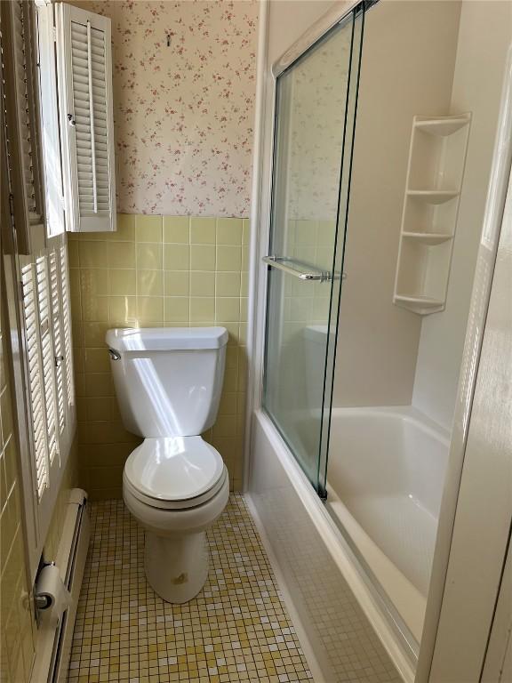 620 S Summit St, Iowa City, IA 52240 - full bath featuring wallpapered walls, a wainscoted wall, toilet, tile patterned floors, and combined bath / shower with glass door