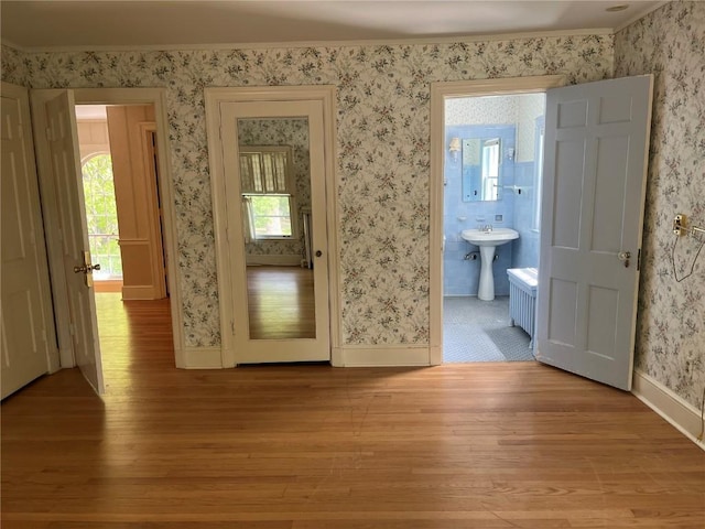 620 S Summit St, Iowa City, IA 52240 - empty room featuring light wood-type flooring, wallpapered walls, baseboards, and a sink