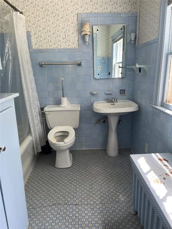 620 S Summit St, Iowa City, IA 52240 - full bathroom with tile walls, toilet, a wainscoted wall, wallpapered walls, and a sink