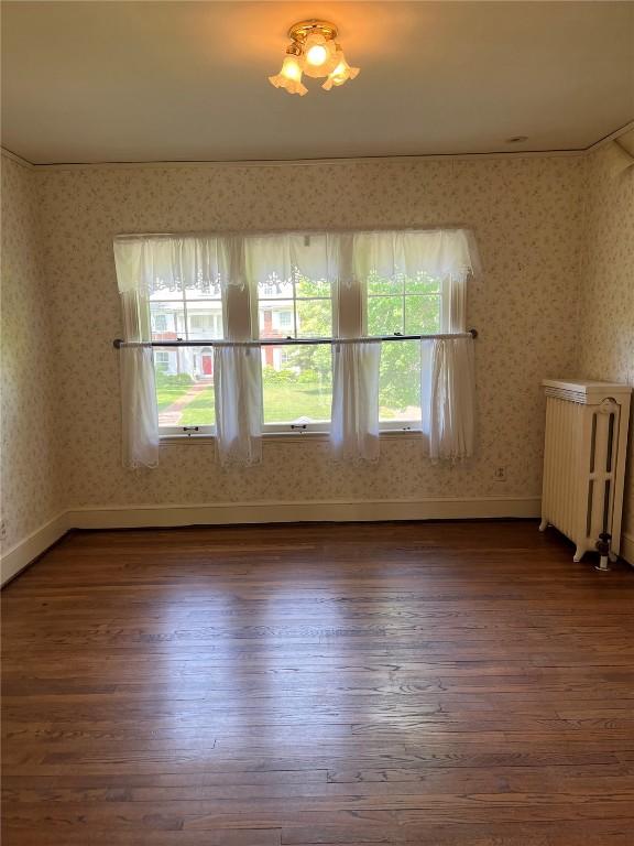 620 S Summit St, Iowa City, IA 52240 - empty room featuring radiator, wood finished floors, wallpapered walls, and baseboards