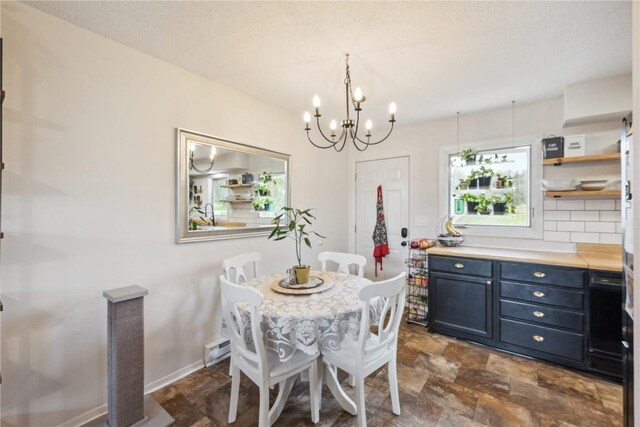 607 E Pershing Dr, Brooklyn, IA 52211 - dining space with stone finish floors, a chandelier, and baseboards