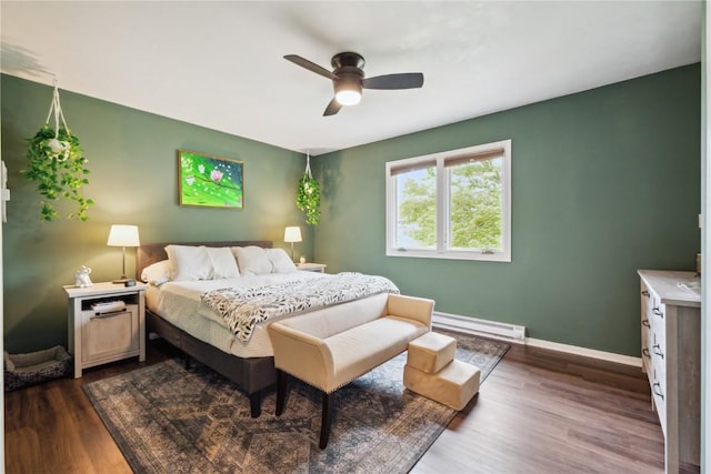 607 E Pershing Dr, Brooklyn, IA 52211 - bedroom featuring a baseboard radiator, dark wood finished floors, baseboards, and ceiling fan