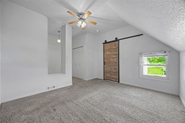 1337 Ellis Blvd NW, Cedar Rapids, IA 52405 - additional living space featuring a textured ceiling, lofted ceiling, ceiling fan, a barn door, and carpet floors