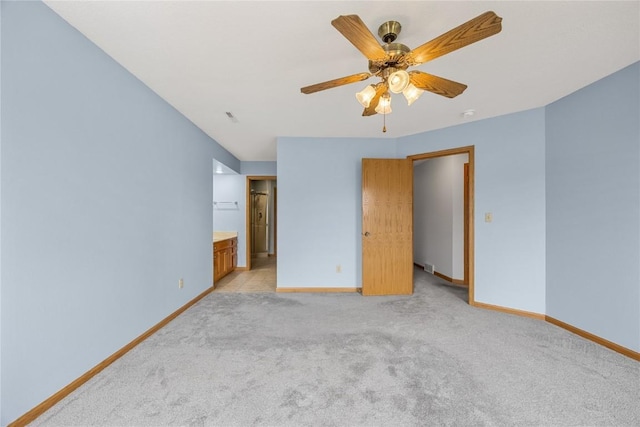 3110 Towne House Dr NE Unit C, Cedar Rapids, IA 52402 - unfurnished bedroom featuring baseboards, light carpet, connected bathroom, and ceiling fan