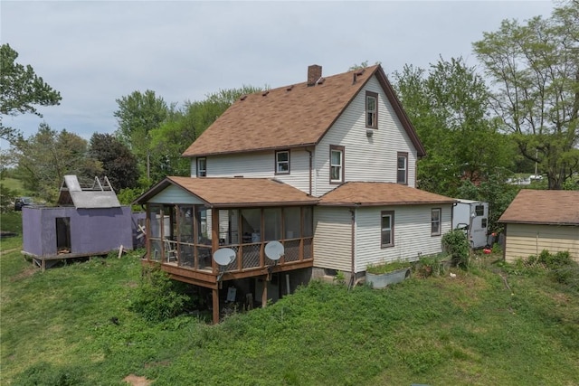3136 155th St, Muscatine, IA 52761 - rear view of house with a sunroom, a chimney, roof with shingles, and a lawn