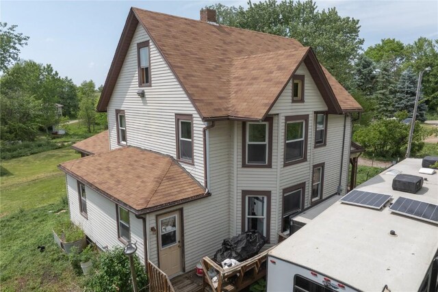 3136 155th St, Muscatine, IA 52761 - view of front of property with a chimney, a shingled roof, a front lawn, and a patio area