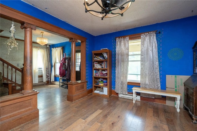 3136 155th St, Muscatine, IA 52761 - interior space with ornate columns, a textured ceiling, hardwood / wood-style floors, stairway, and baseboards