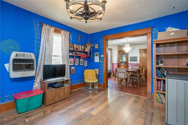 3136 155th St, Muscatine, IA 52761 - game room with a chandelier, heating unit, a textured ceiling, hardwood / wood-style floors, and baseboards
