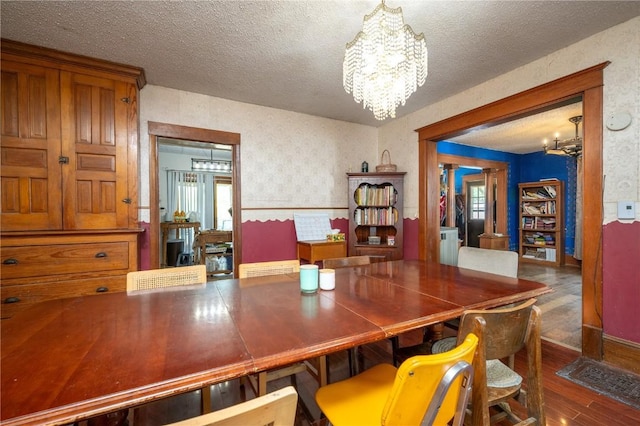 3136 155th St, Muscatine, IA 52761 - dining room with a chandelier, wood-type flooring, a textured ceiling, and wallpapered walls