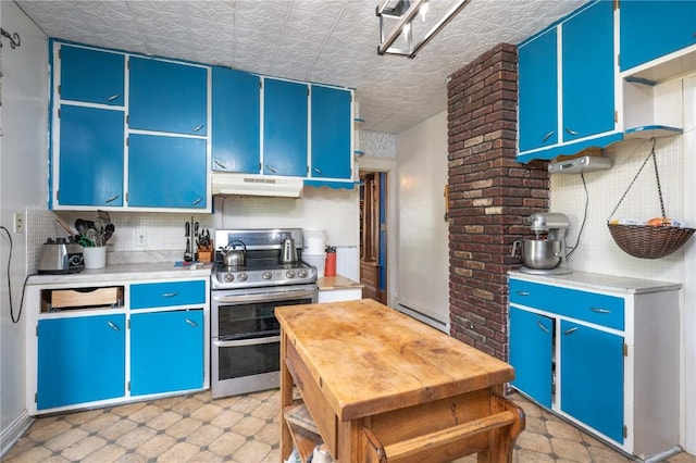 3136 155th St, Muscatine, IA 52761 - kitchen featuring double oven range, under cabinet range hood, light countertops, blue cabinetry, and an ornate ceiling