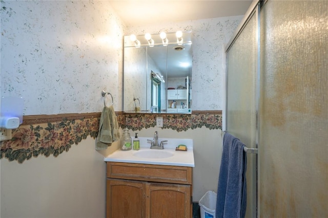 3136 155th St, Muscatine, IA 52761 - bathroom featuring wallpapered walls, a stall shower, and vanity