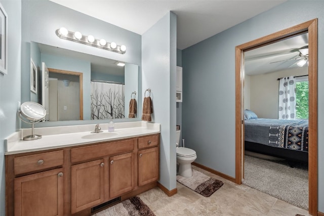 1075 Twilight Dr, North Liberty, IA 52317 - ensuite bathroom featuring toilet, vanity, ceiling fan, and baseboards