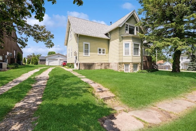 205 2nd Ave, Atkins, IA 52206 - view of side of property with a yard, a shingled roof, a garage, and an outbuilding