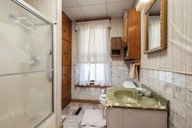 205 2nd Ave, Atkins, IA 52206 - bathroom with toilet, a shower stall, vanity, plenty of natural light, and a drop ceiling