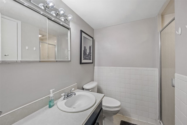 2222 1st Ave NE Unit 107, Cedar Rapids, IA 52402 - full bath featuring vanity, a stall shower, tile walls, tile patterned floors, and a wainscoted wall