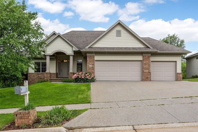 959 Tamarack Trl, Iowa City, IA 52245 - view of front of property with brick siding, an attached garage, concrete driveway, a front lawn, and roof with shingles