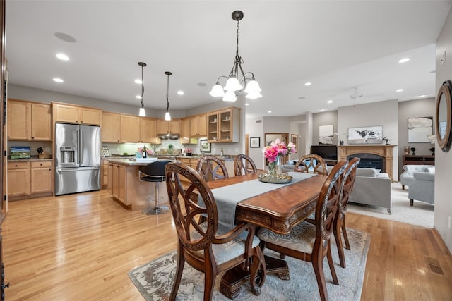 959 Tamarack Trl, Iowa City, IA 52245 - dining space with light wood-style floors, recessed lighting, a fireplace, a chandelier, and a ceiling fan
