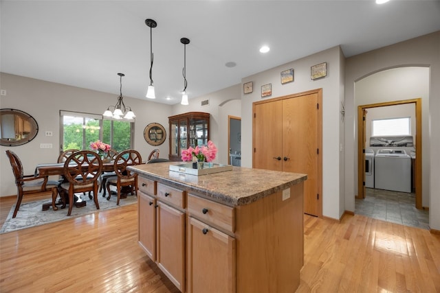 959 Tamarack Trl, Iowa City, IA 52245 - kitchen with arched walkways, a kitchen island, washer and dryer, light wood finished floors, and recessed lighting