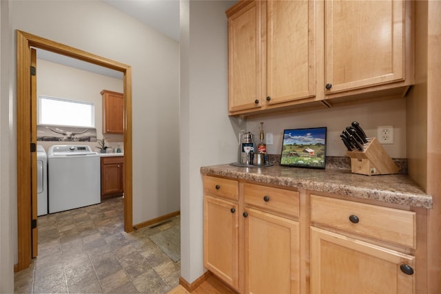 959 Tamarack Trl, Iowa City, IA 52245 - bar featuring washer and clothes dryer, stone finish flooring, and baseboards