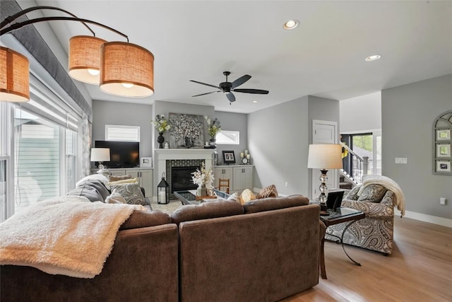 2925 Pine Hill Trce, Coralville, IA 52241 - living room featuring light wood finished floors, a glass covered fireplace, ceiling fan, recessed lighting, and baseboards