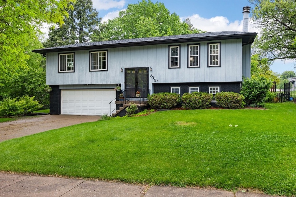 305 N Mount Vernon Dr, Iowa City, IA 52245 - raised ranch featuring a front lawn, an attached garage, concrete driveway, and french doors