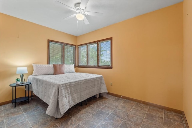 100 E Welsh St, Williamsburg, IA 52361 - bedroom with baseboards, stone finish floors, and ceiling fan