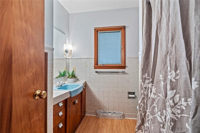 100 E Welsh St, Williamsburg, IA 52361 - bathroom featuring vanity, tile walls, wainscoting, wood finished floors, and a shower with curtain
