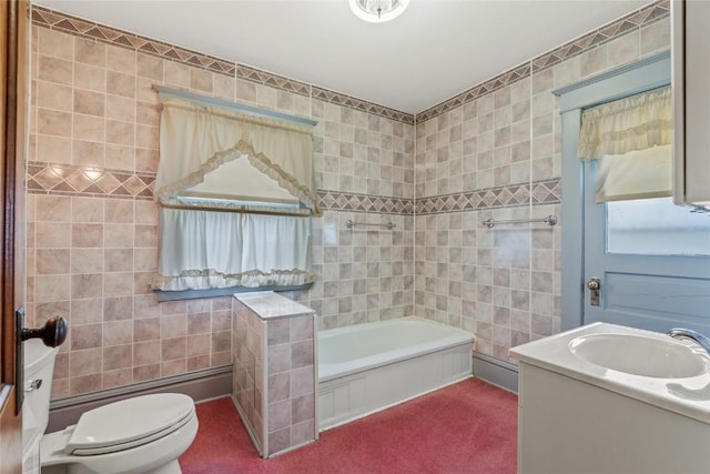 100 E Welsh St, Williamsburg, IA 52361 - bathroom with tile walls, a tub to relax in, toilet, and vanity