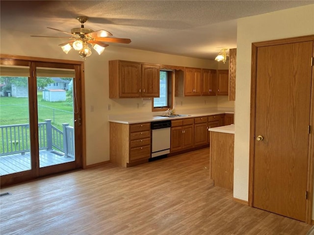 202 S 9th Ave, Vinton, IA 52349 - kitchen featuring white dishwasher, brown cabinets, light countertops, light wood-type flooring, and ceiling fan