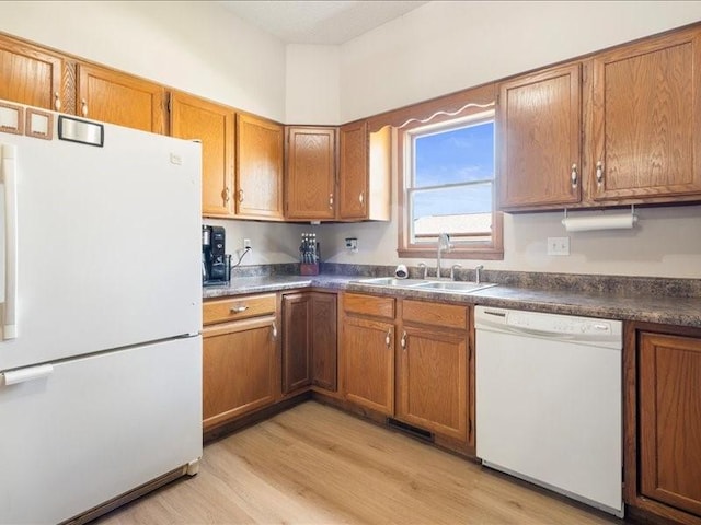 433 S Iowa St, Solon, IA 52333 - kitchen featuring white appliances, brown cabinets, light wood-style floors, and dark countertops