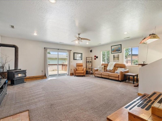 433 S Iowa St, Solon, IA 52333 - living area with a textured ceiling, a wood stove, a ceiling fan, healthy amount of natural light, and light carpet