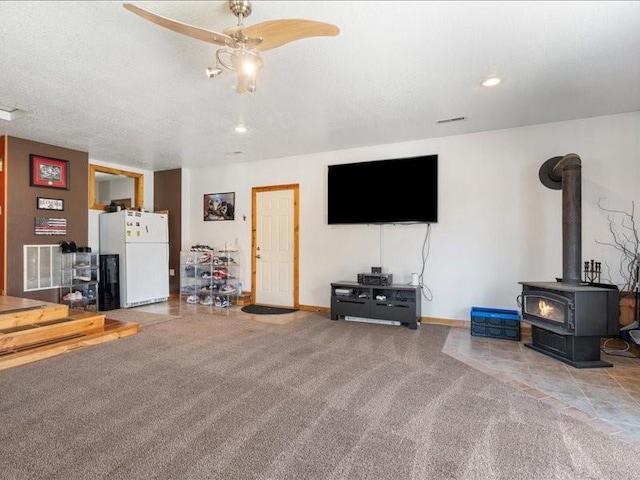 433 S Iowa St, Solon, IA 52333 - carpeted living area with a ceiling fan, a wood stove, and recessed lighting