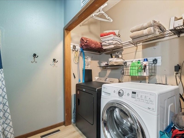 433 S Iowa St, Solon, IA 52333 - washroom with washer and clothes dryer and light wood-style flooring