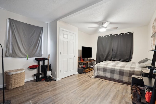 3007 Ravenwood Ter NW, Cedar Rapids, IA 52405 - bedroom featuring wood finished floors, a textured ceiling, baseboards, and a ceiling fan