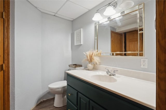 3007 Ravenwood Ter NW, Cedar Rapids, IA 52405 - bathroom featuring vanity, toilet, a paneled ceiling, and wood finished floors