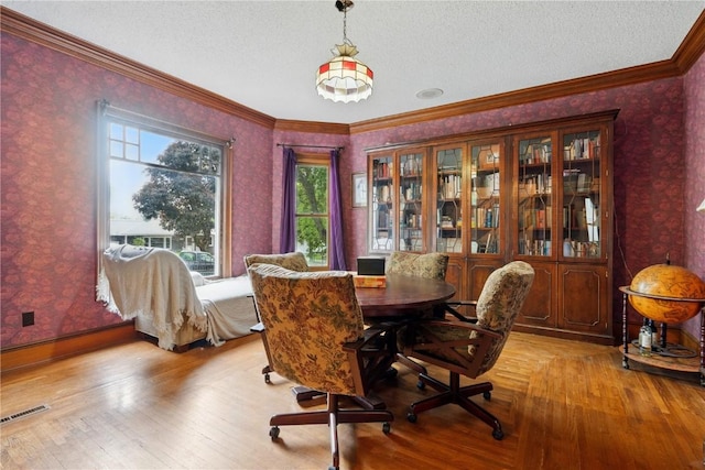 205 S Ford St, Anamosa, IA 52205 - dining area with wallpapered walls, ornamental molding, a textured ceiling, light wood-style flooring, and baseboards