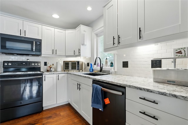 205 S Ford St, Anamosa, IA 52205 - kitchen with black appliances, a sink, decorative backsplash, light stone counters, and recessed lighting