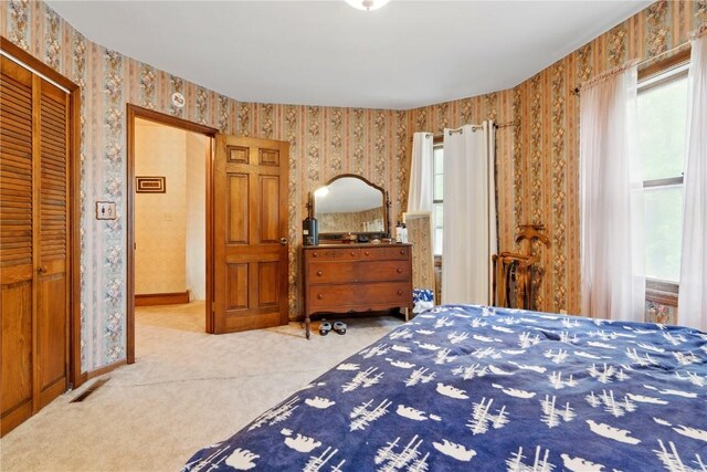 205 S Ford St, Anamosa, IA 52205 - bedroom with wallpapered walls, carpet flooring, a closet, and baseboards