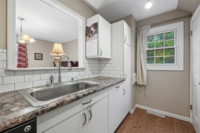 3051 Wayne Ave Unit 64, Iowa City, IA 52240 - kitchen featuring a sink, baseboards, white cabinets, and backsplash