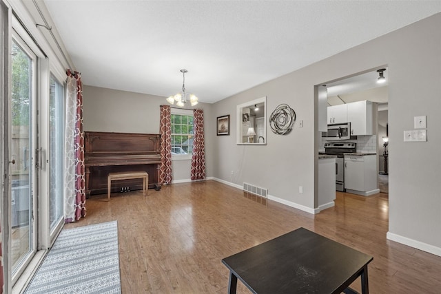 3051 Wayne Ave Unit 64, Iowa City, IA 52240 - living area with a chandelier, light wood finished floors, and baseboards