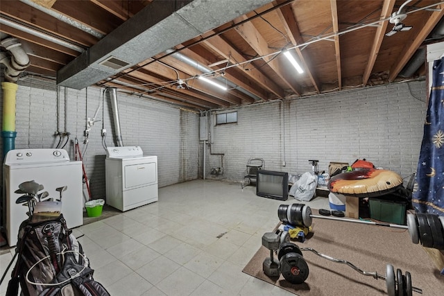 3051 Wayne Ave Unit 64, Iowa City, IA 52240 - unfinished below grade area featuring washer and clothes dryer, tile patterned flooring, and brick wall
